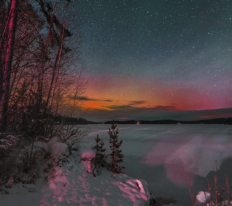 Arafed view of a lake with a bright pink light in the sky (landscape, snow)