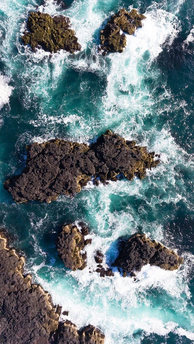 Vagues bleues s'écrasant sur des affleurements rocheux