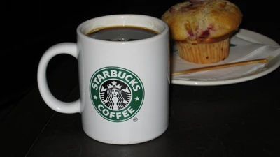 Caneca de café Starbucks com café coado e muffin em um pires