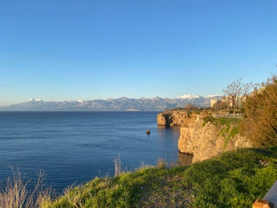 Serene Küstenlandschaft mit azurblauen Gewässern und schneebedeckten Bergen