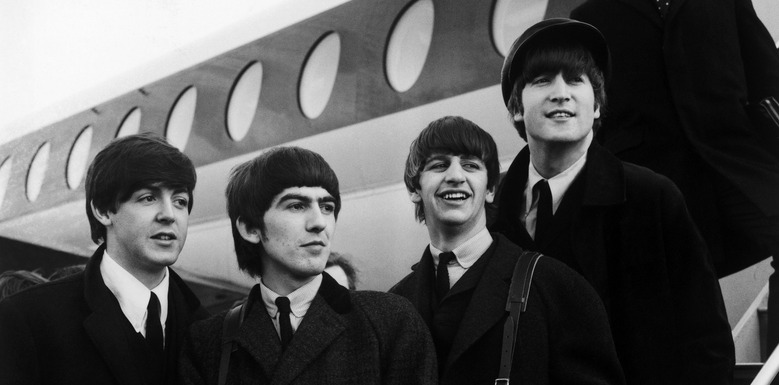 Une photo en noir et blanc d'un groupe de personnes debout sur un avion (john lennon, the beatles, george harrison, paul mccartney, monochrome)