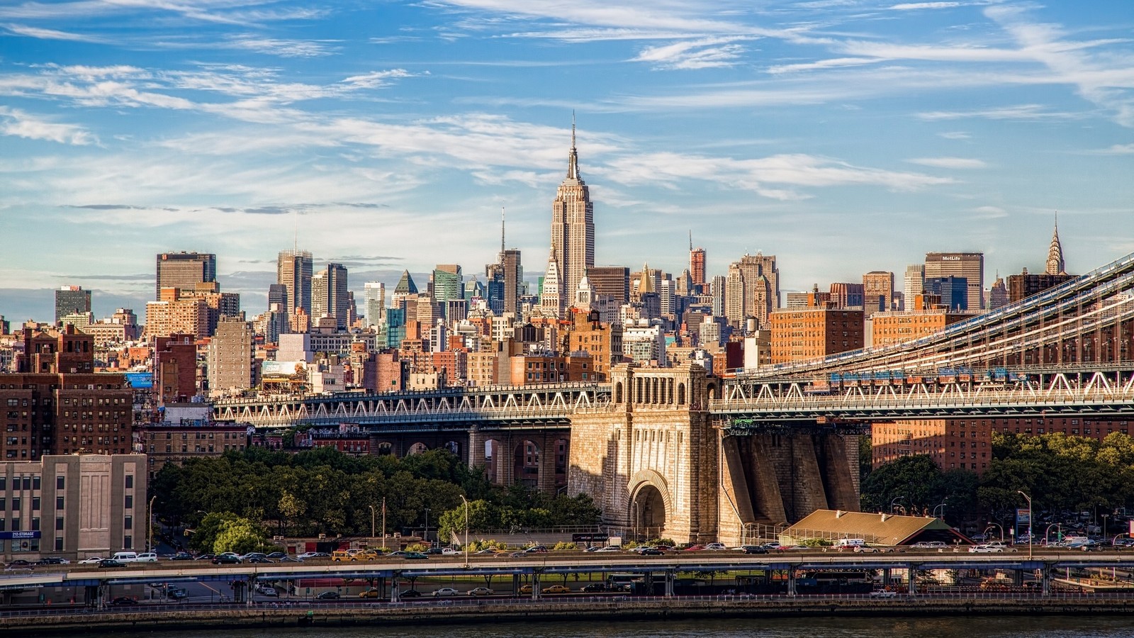 Uma vista de uma ponte que atravessa um rio com uma cidade ao fundo (paisagem urbana, cidade, área urbana, linha do horizonte, metrópole)