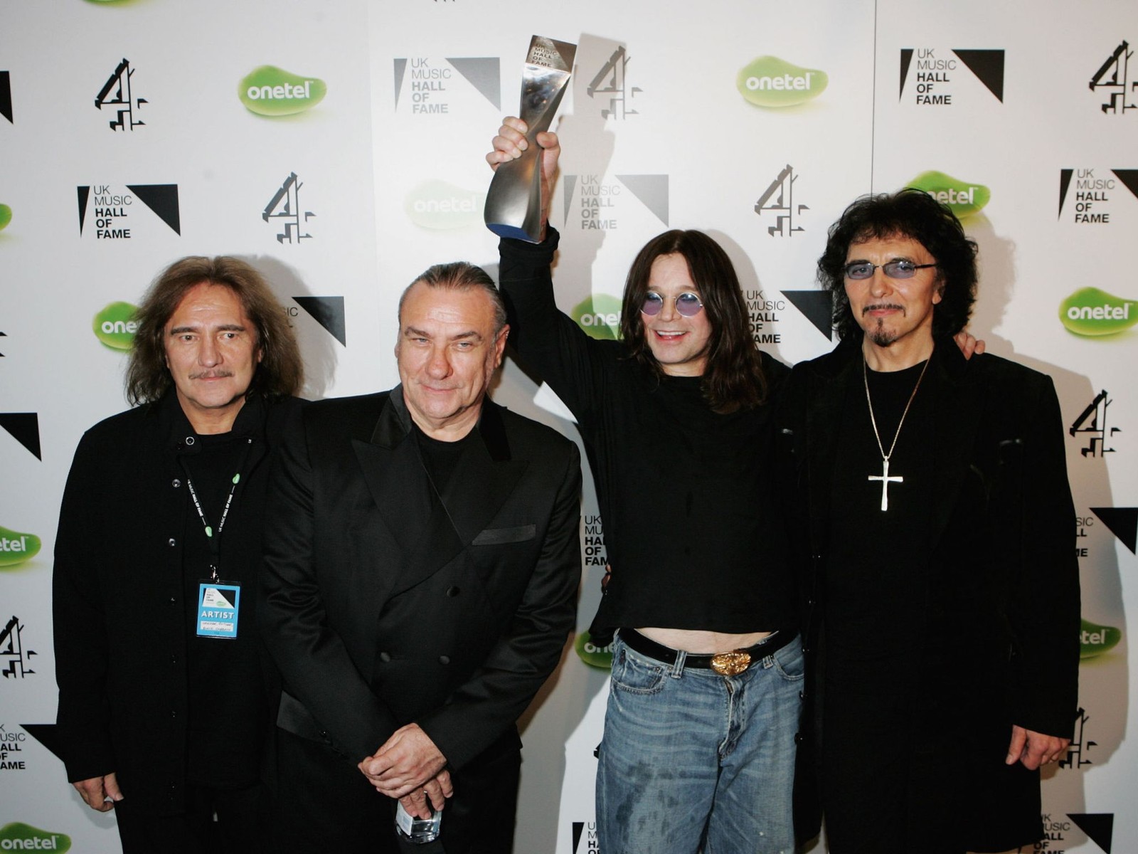 Grupo árabe de hombres de pie uno al lado del otro sosteniendo un trofeo (ozzy osbourne, black sabbath, evento, pavimentación, música)