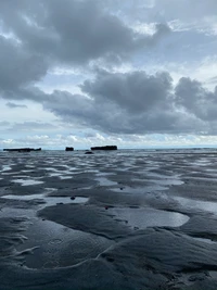 Poças de maré refletindo nuvens sob um céu nublado em Bali, Indonésia.