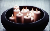 Elegant Arrangement of Flickering Candles in a Modern Bowl