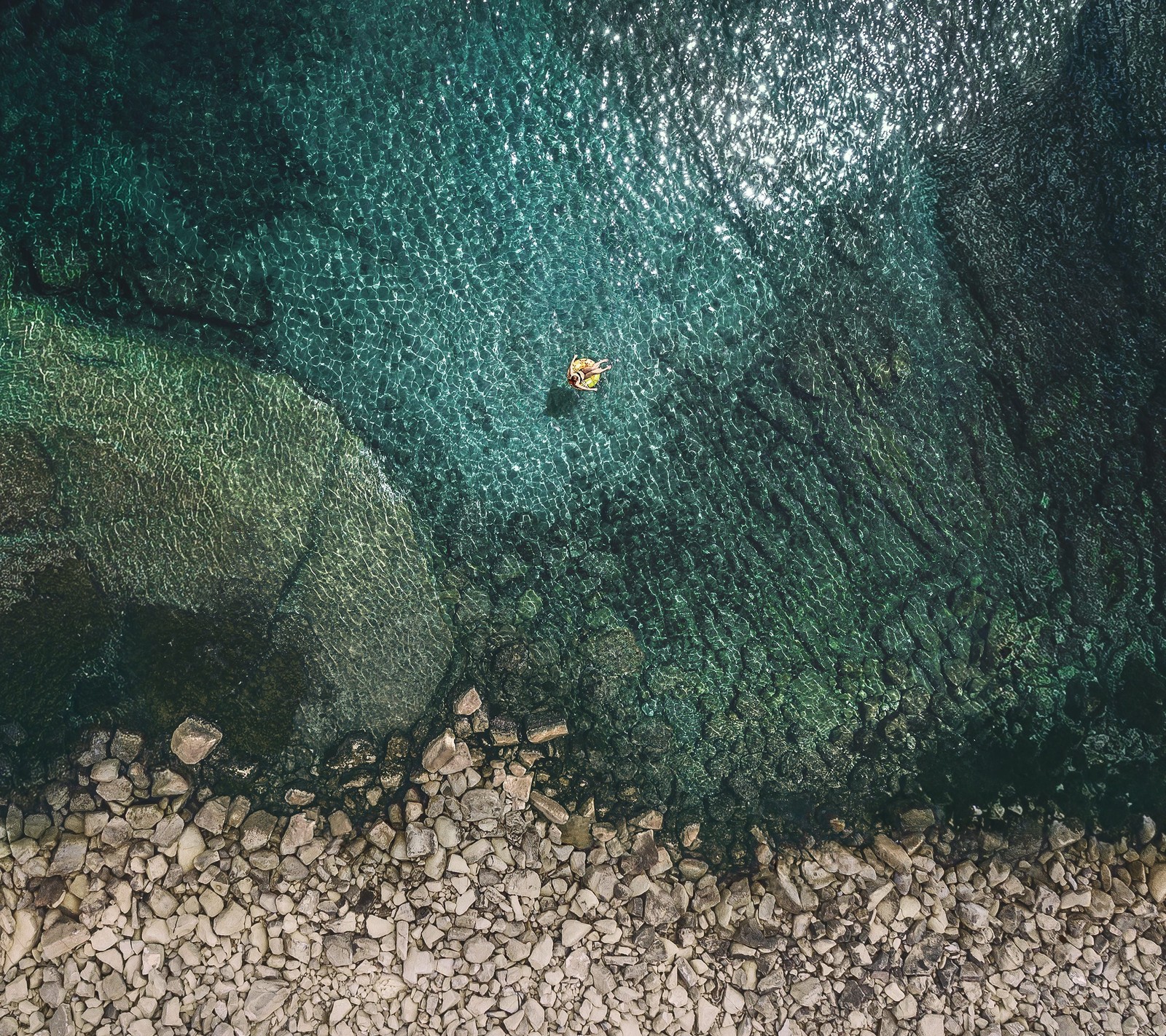 Aerial view of a boat in the water near a rocky shore (11, 929, android, ios, stock)