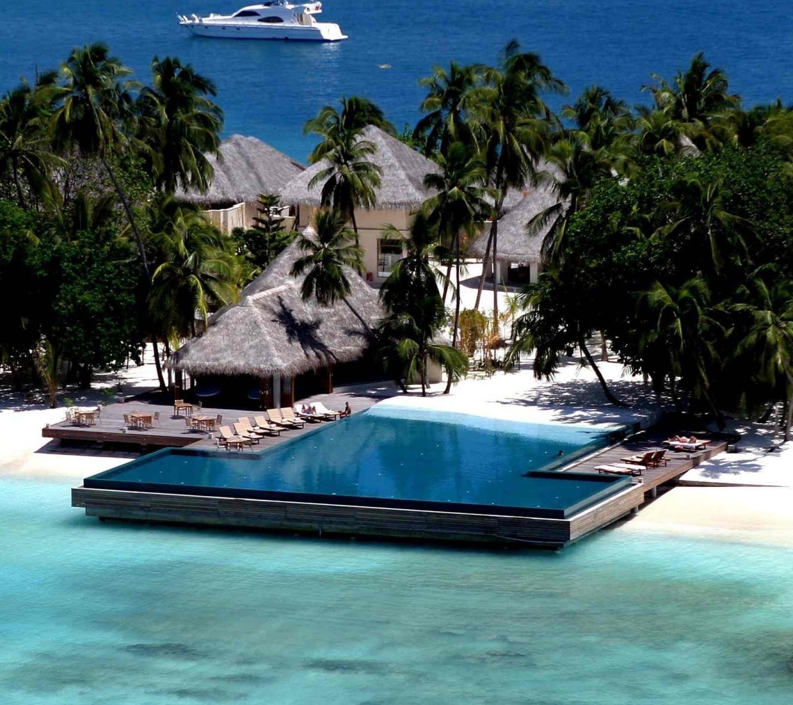 There is a pool in the middle of the water surrounded by palm trees (beach, nature, ocean)