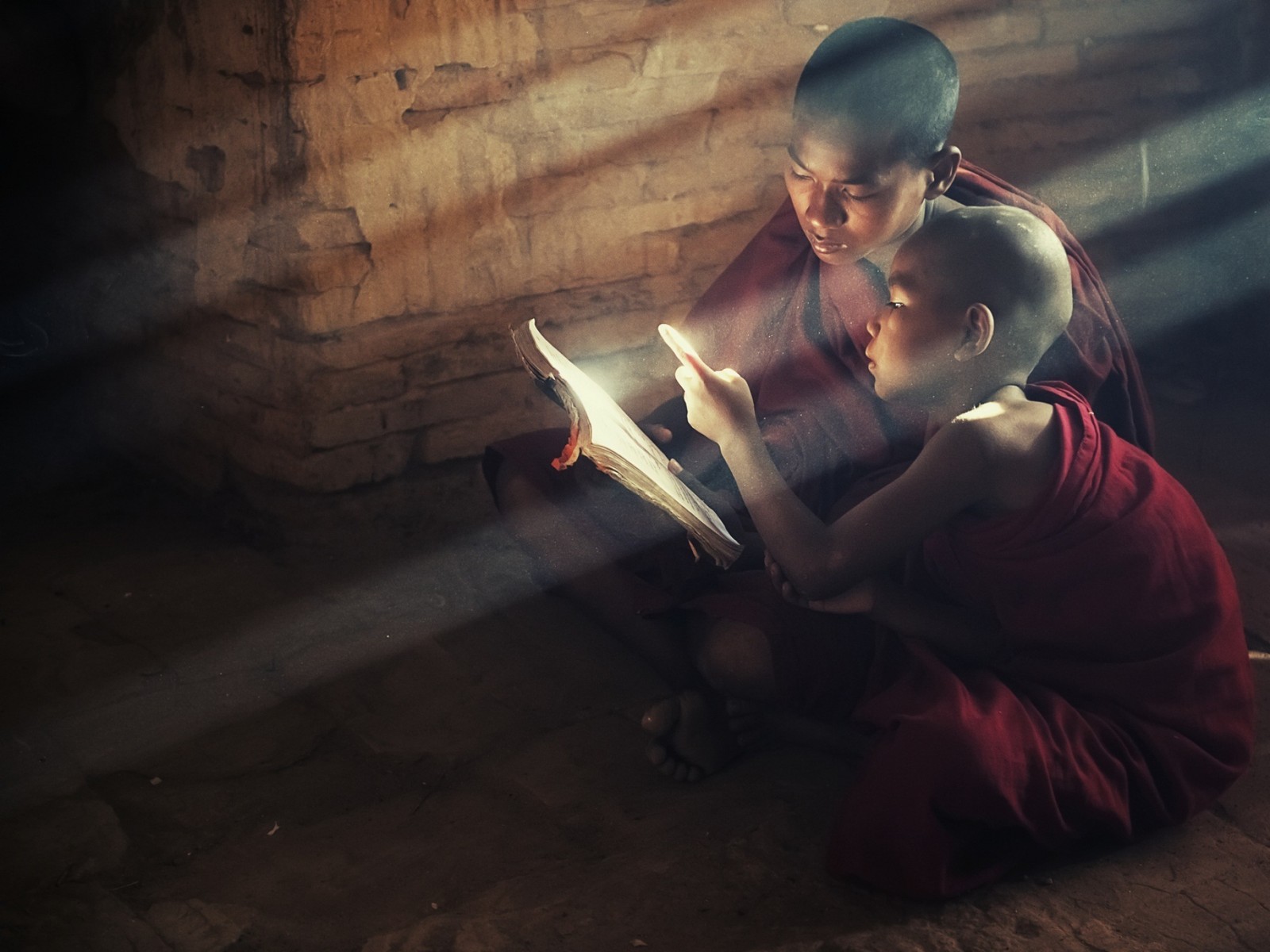 Un monje árabe leyendo un libro a un niño en una habitación oscura (ligero, humano, medianoche, budismo, templo)