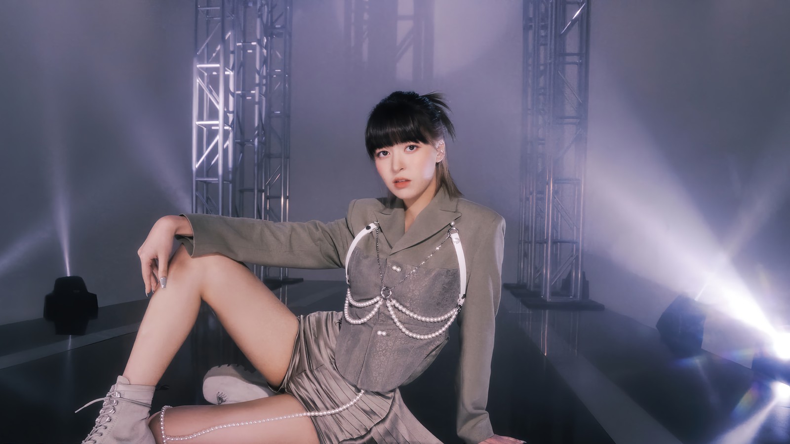 Femme araffe assise sur une scène avec une paire de chaussures (nmixx, 엔믹스, kpop, groupe de filles coréen, korean girl group)