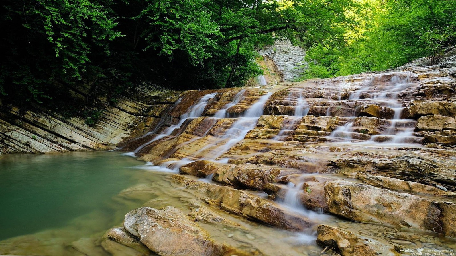 Un primer plano de una cascada con agua fluyendo (cascada, cauce, reserva natural, recursos hídricos, naturaleza)