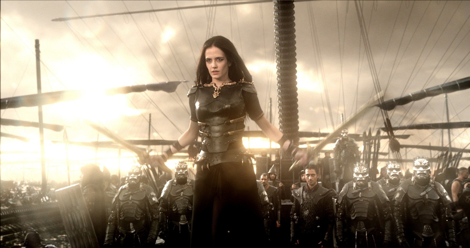 Uma mulher de vestido preto em pé na frente de um grupo de soldados (300 rise of an empire, 300, desempenho, entretenimento, concerto)