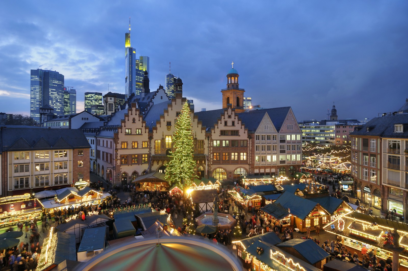 Une vue d'un marché de noël avec un arbre de noël et un manège (zone urbaine, point de repère, ville, paysage urbain, nuit)