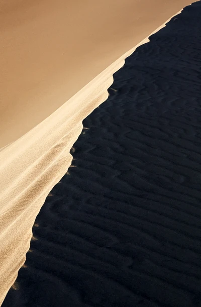 Dunas de areia contrastantes sob um horizonte claro