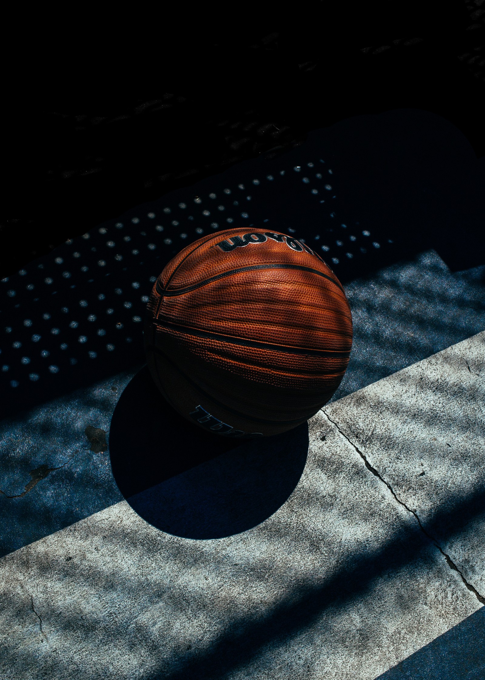 Arafed basketball ball on a court with shadows on the ground (basketball, ball, space, wood, basketball player)