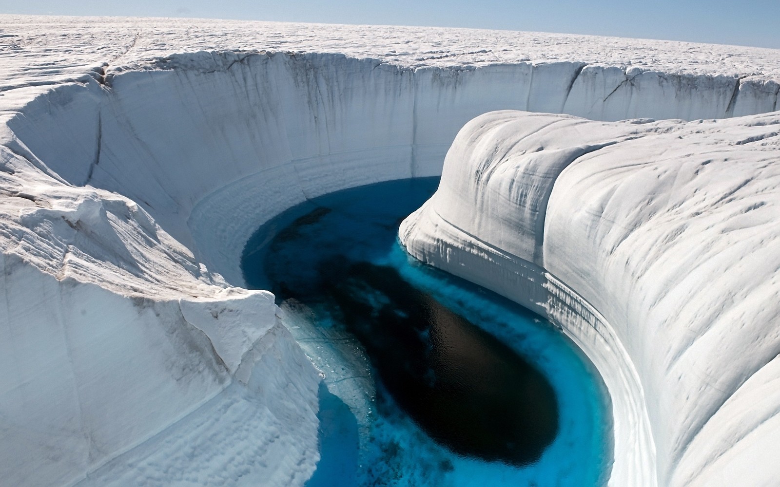 Iceberg aéreo com uma piscina de água azul profunda. (gelo, groenlândia, água, forma glacial, calota de gelo)