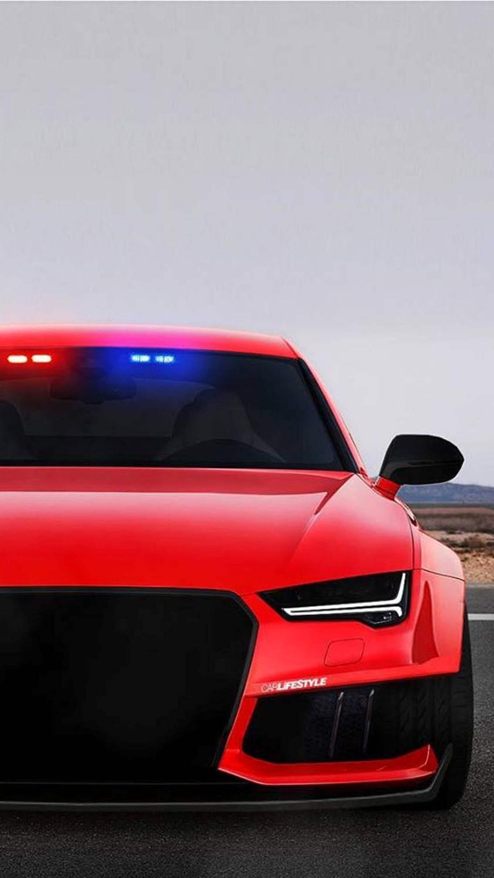 A close up of a red police car with a blue light on (audi, car, police, red)