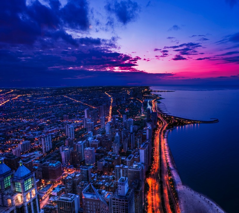 Une vue d'une ville la nuit avec une longue exposition sur l'océan (chicago, ville, violet, ciel, coucher de soleil)