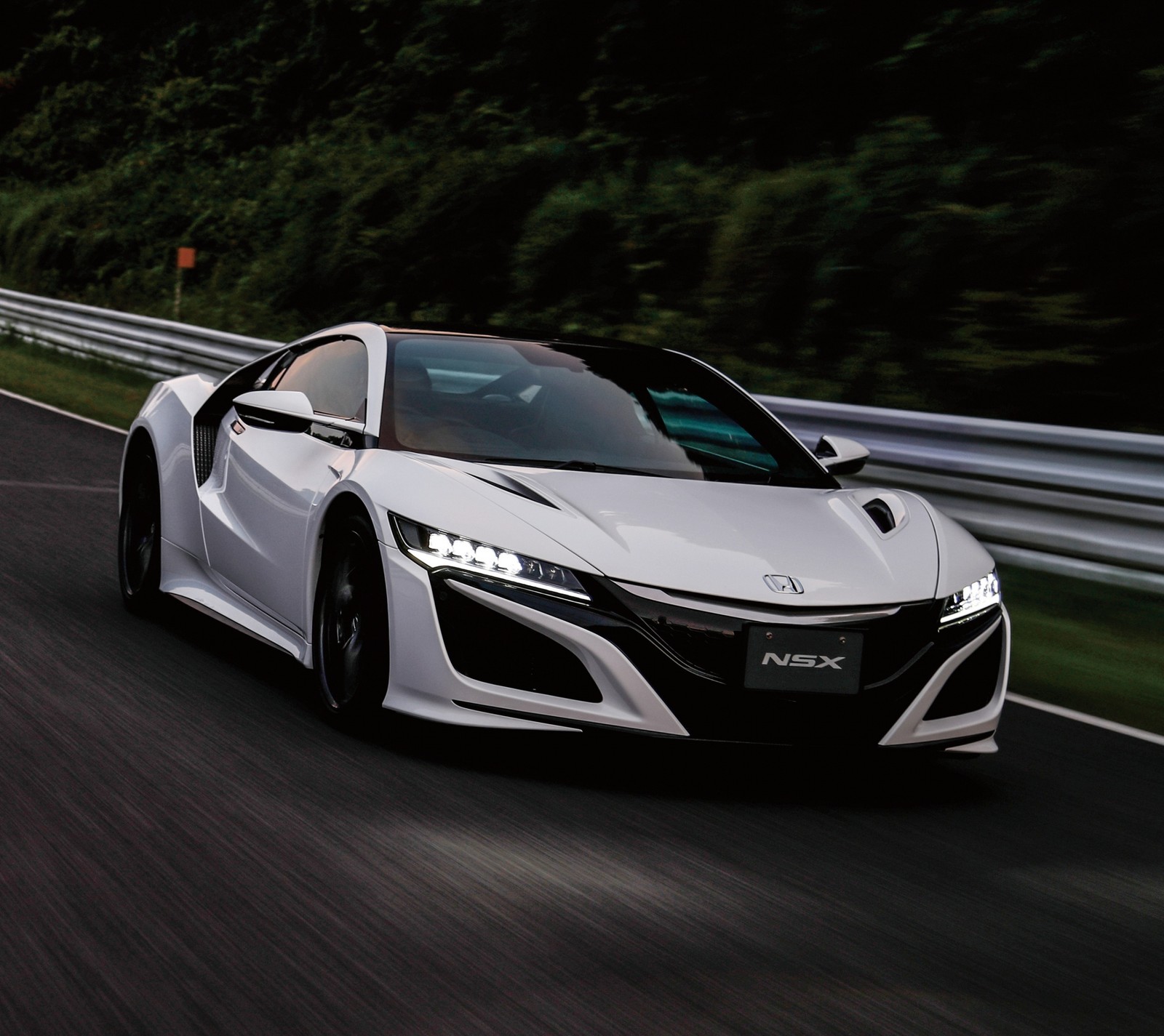 A close up of a white sports car driving on a road (honda, japan, nsx, white)