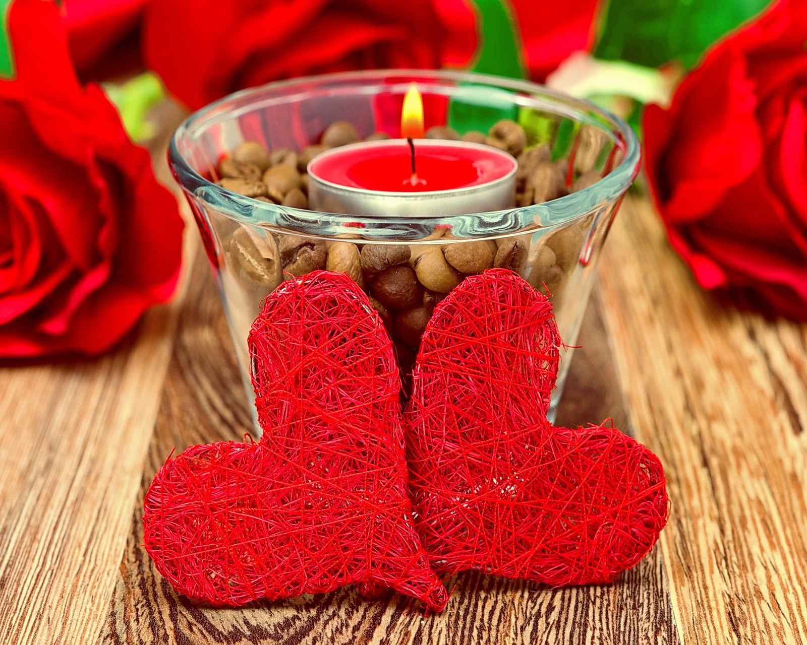 Des bougies et des roses rouges sont placées dans un bol en verre avec une bougie (cœurs, amour, roses)