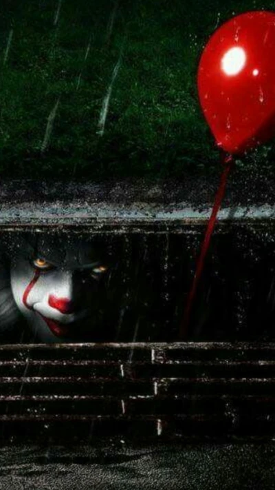 Pennywise der Clown taucht aus den Schatten mit einem roten Ballon auf