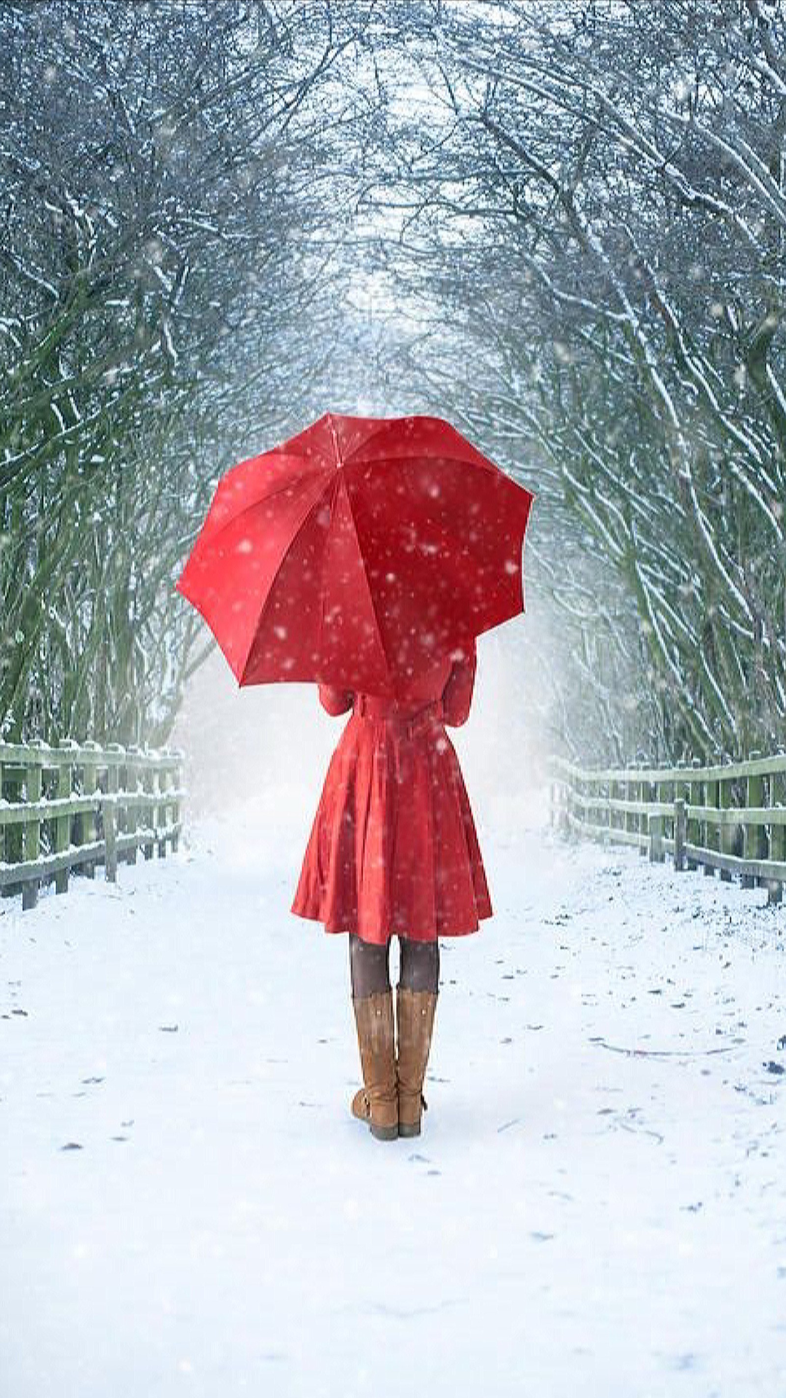 Uma mulher caminhando por um caminho coberto de neve com um guarda-chuva (inverno, neve, árvores, vestido vermelho, menina)