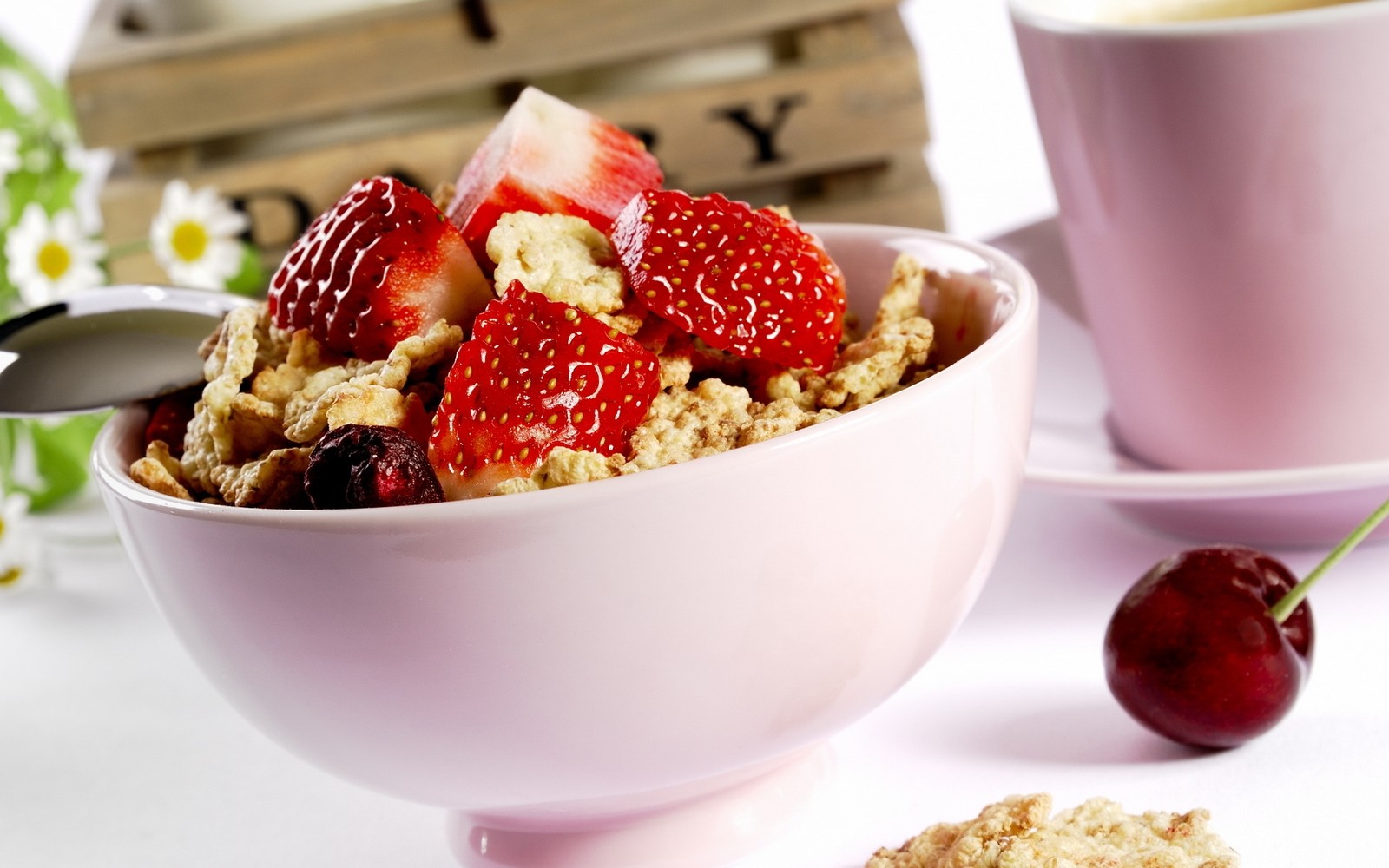 There is a bowl of cereal with strawberries and cherries in it (breakfast cereal, breakfast, muesli, food, vegetarian food)