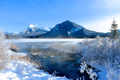 Paisaje invernal sereno con lago glacial y majestuosas montañas