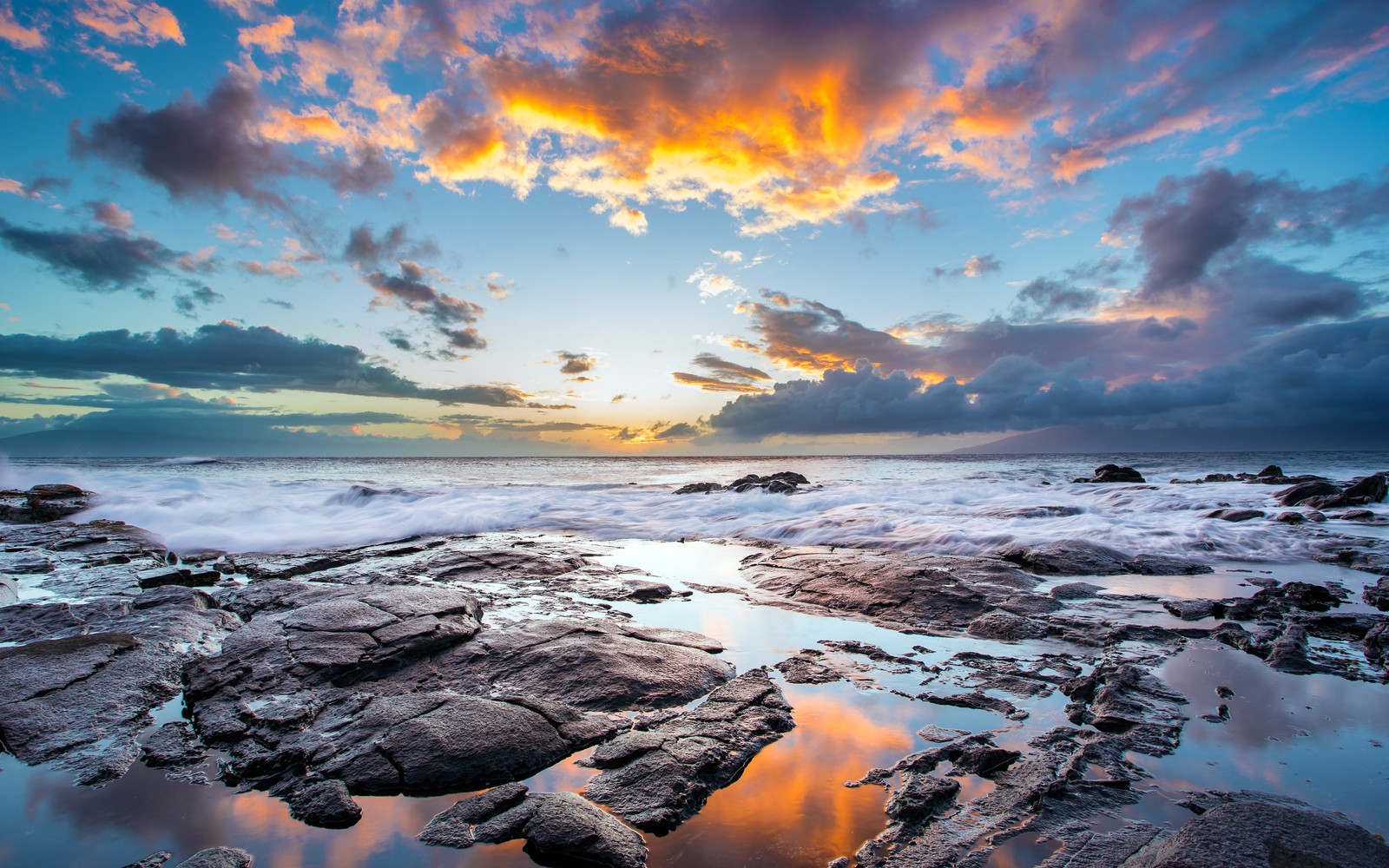 Pôr do sol sobre o oceano com pedras e água (água, nuvem, recursos hídricos, atmosfera, natureza)