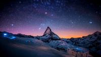 Montagnes étoilées sous un ciel crépusculaire