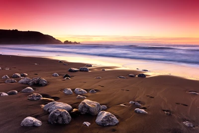 Atardecer tranquilo sobre la playa Rockaway con suaves olas y orilla de guijarros