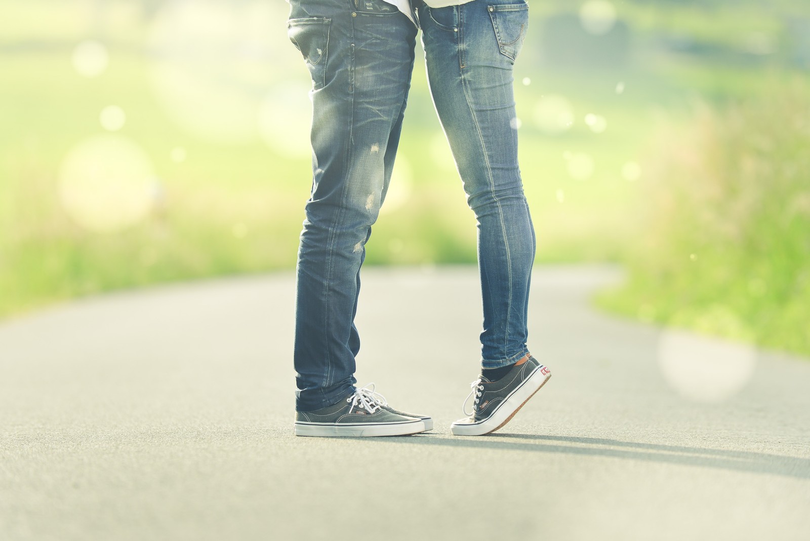 Deux personnes se tiennent sur une route par la main (bonheur, romance, amitié, jeans, denim)