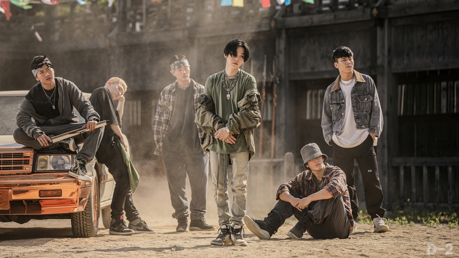 Several men are standing around a truck in a dirt field (agust d, daechwita, 대취타, suga, 슈가)