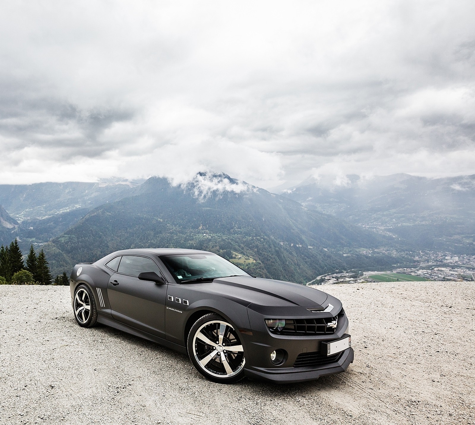 Arafed sports car parked on a gravel road with mountains in the background (camaro, chevrolet, chevrolet camaro, chevrolet camaro ss, ss)