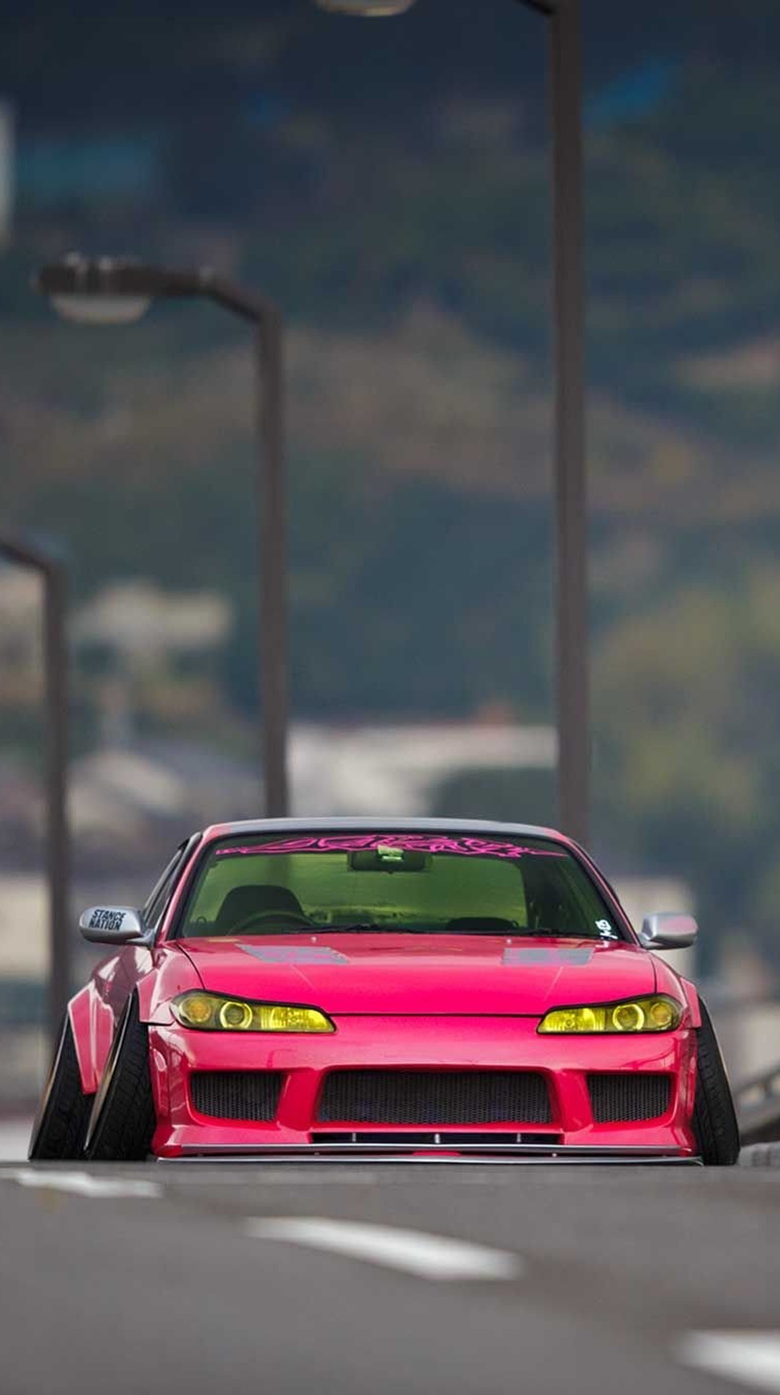 There is a pink car that is parked on the side of the road (car, modified, nissan, pink)