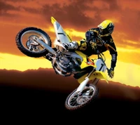 Pilote de motocross dynamique effectuant un stunt aérien contre un arrière-plan de coucher de soleil vibrant.