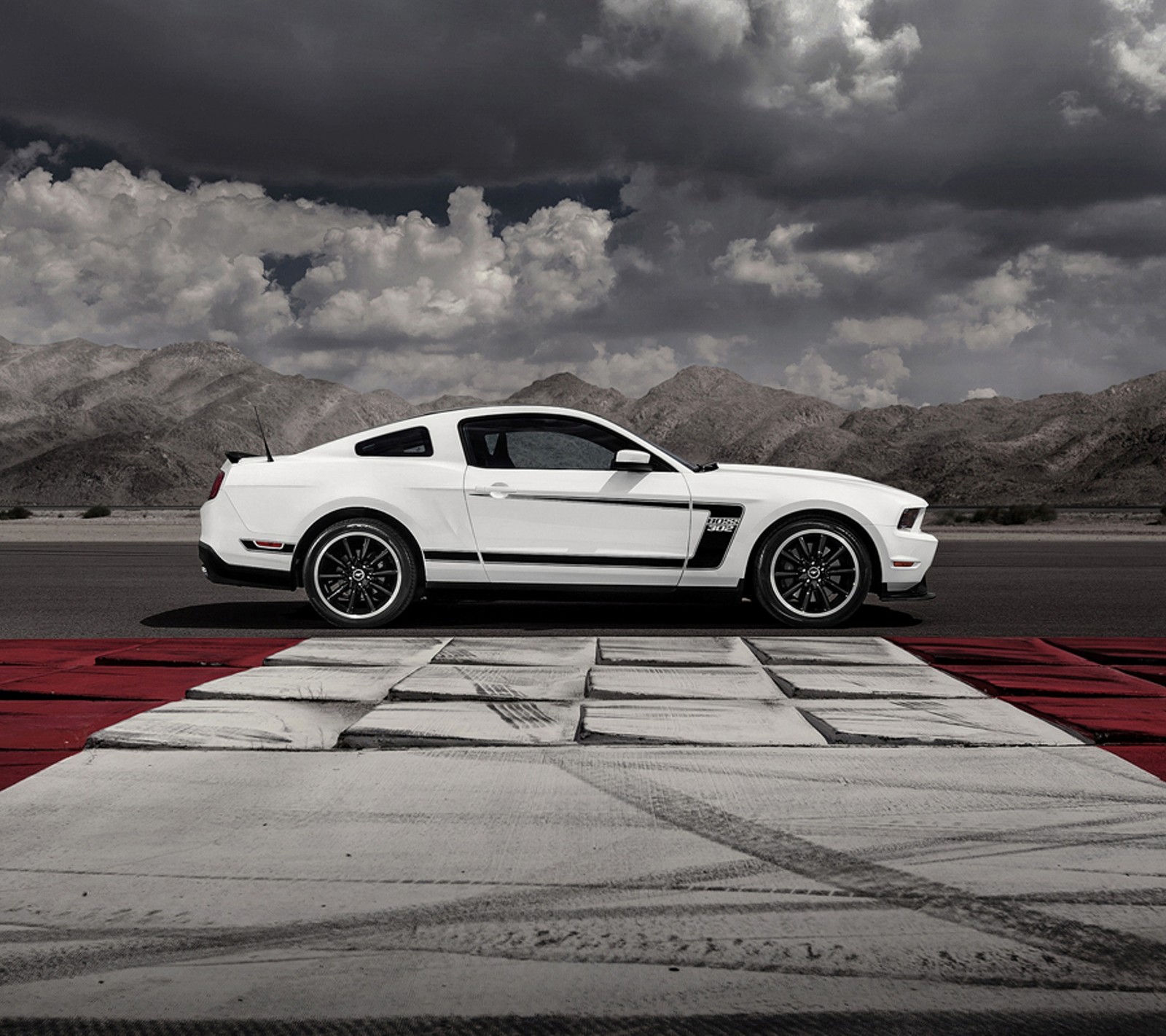 Um mustang arafed na pista com um céu nublado ao fundo (carro, ford, mustang)