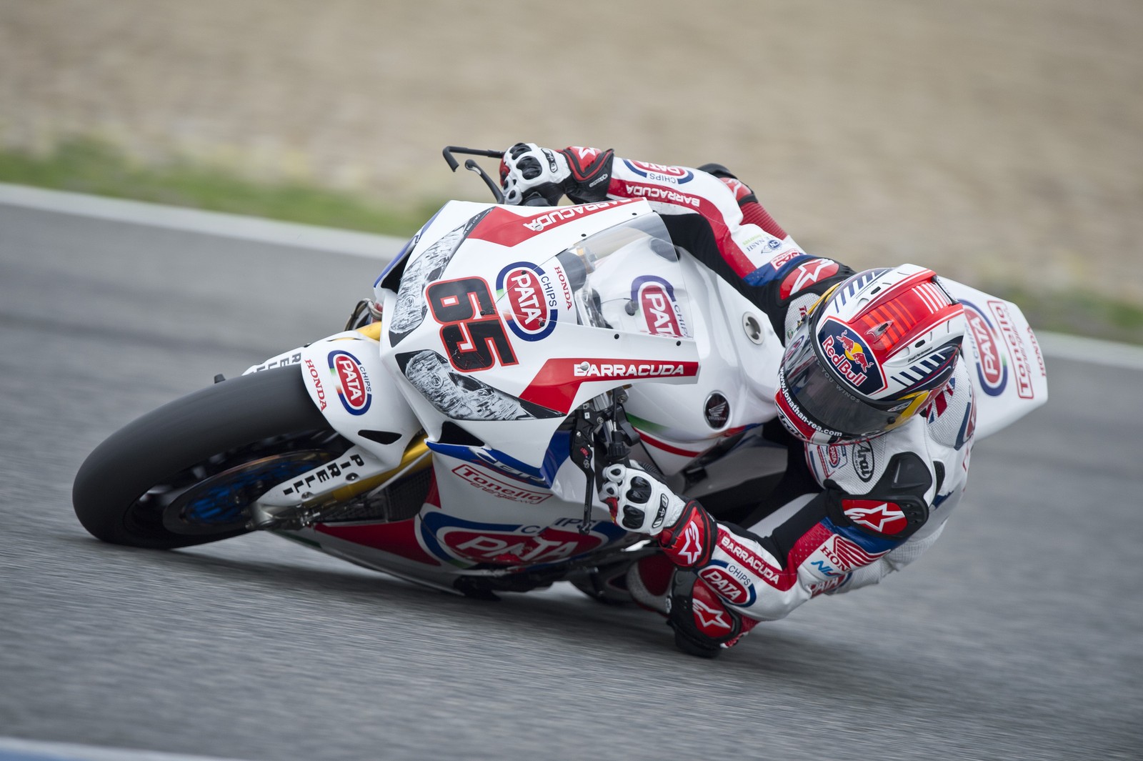 Coureur de moto flou se penchant sur une piste avec un casque (course de superbike, voiture, casque de moto, courses, sport automobile)