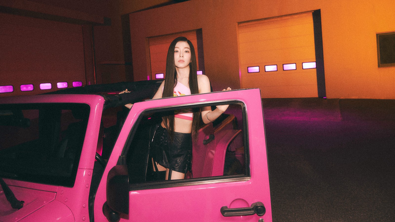 Una mujer de pie en un coche rosa con una puerta rosa (irene, 아이린, bae joo hyun, bae ju hyun, 배주현)