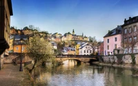 Malerspiegelung bunter Gebäude entlang eines ruhigen Wasserwegs in Luxemburg