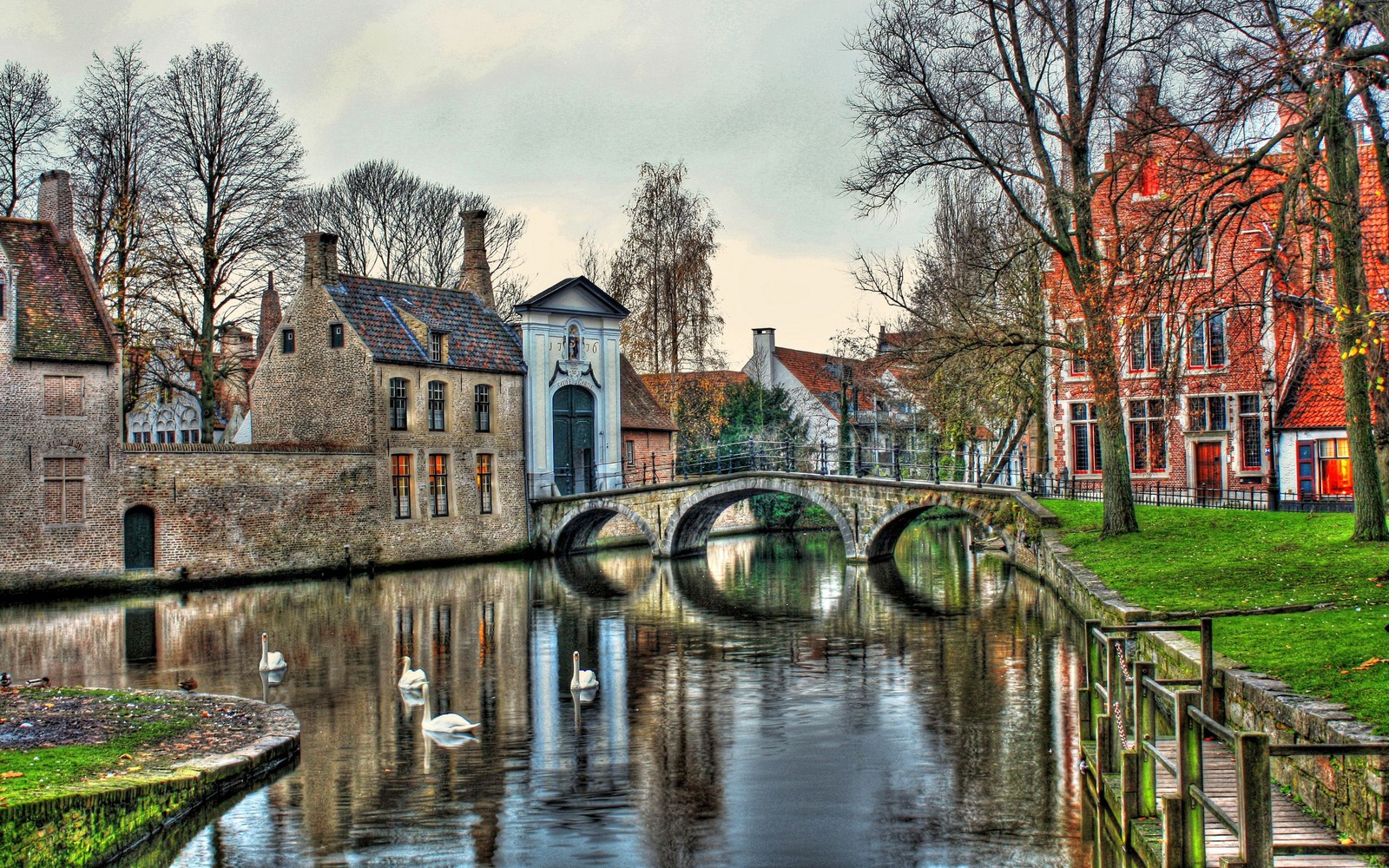 Vue arabe d'un canal avec un pont et des bâtiments en arrière-plan (bruges, voie navigable, canal, eau, réflexion)