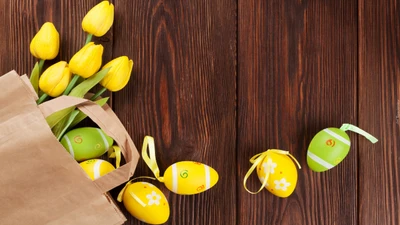 Tulipanes amarillos y huevos de Pascua coloridos sobre una superficie de madera