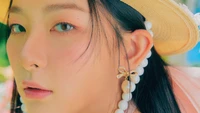 Seulgi do Red Velvet captura a atenção com sua beleza etérea, adornada com acessórios estilosos e uma expressão suave e sonhadora, refletindo o tema vibrante de "Feel My Rhythm" do Festival ReVe 2022.