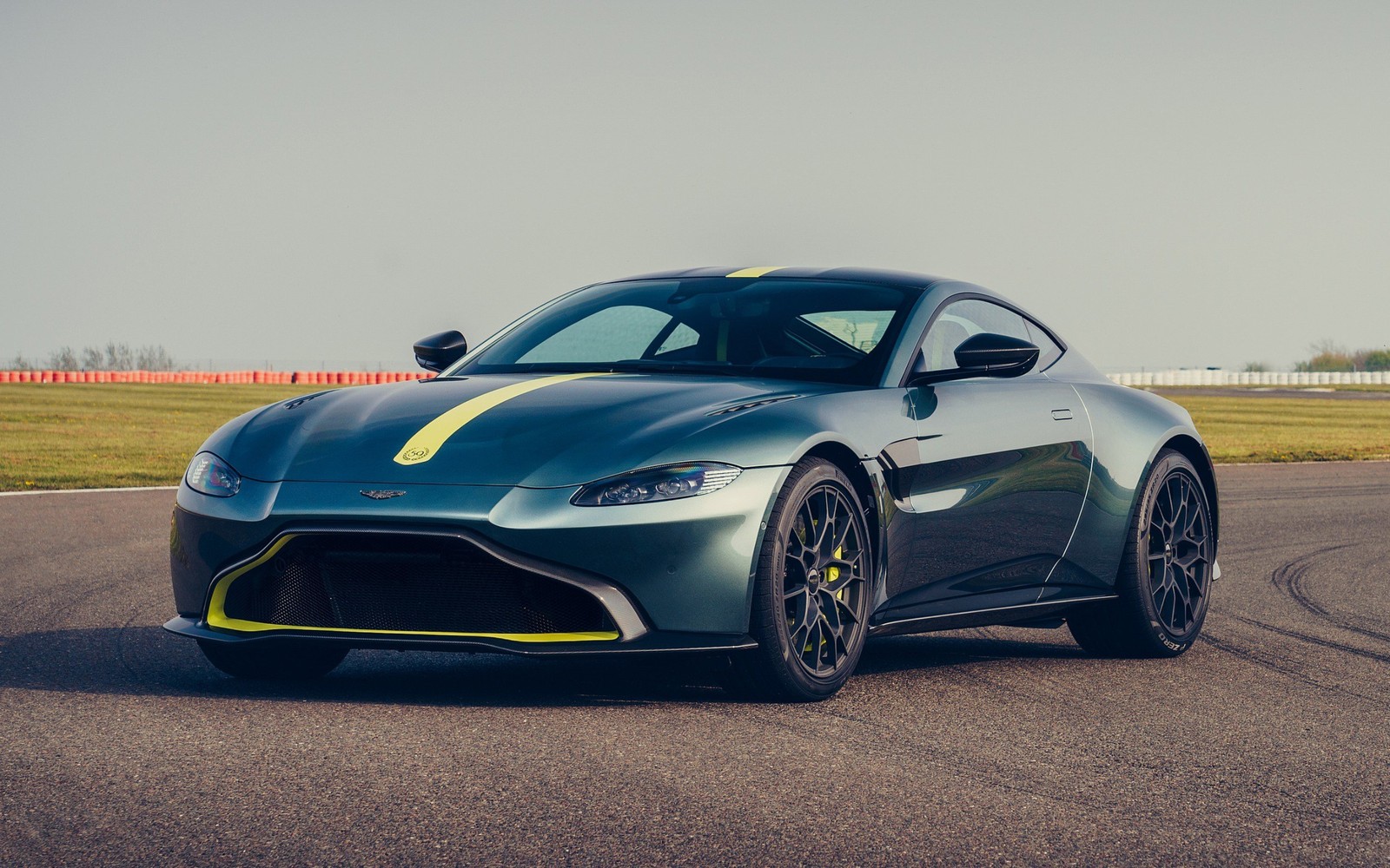 A grey and yellow aston vantage driving on a track (aston martin, aston martin vantage, aston martin vanquish, sports car, cars)