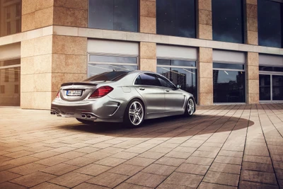 Eleganter Mercedes-Benz S-Klasse mit Leichtmetallrädern, stilvoll vor einem modernen architektonischen Hintergrund geparkt.