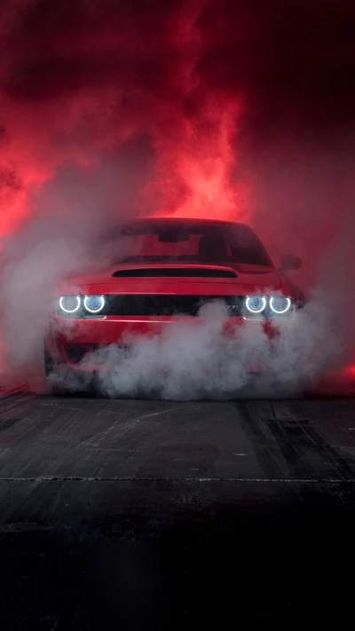 Dodge Challenger rojo emergiendo del humo con fondo ardiente