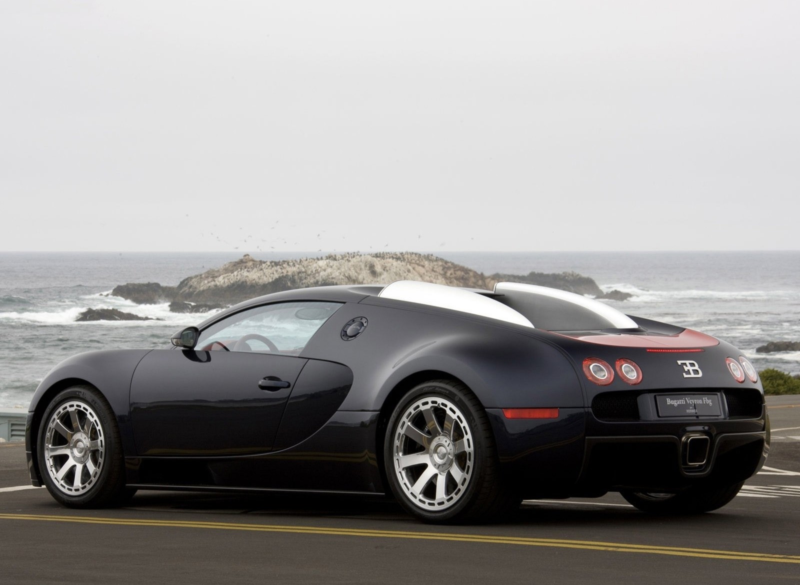 Un buggy sur la route près de l'océan avec une roche en arrière-plan. (auto, bugatti veyron, voiture, véhicule)