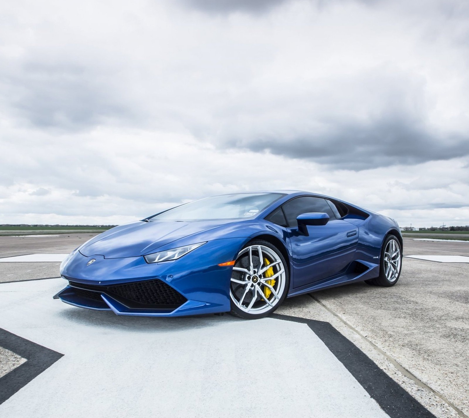 Um close-up de um carro esportivo azul estacionado em uma pista de pouso (azul, carro, huracan, lamborghini)