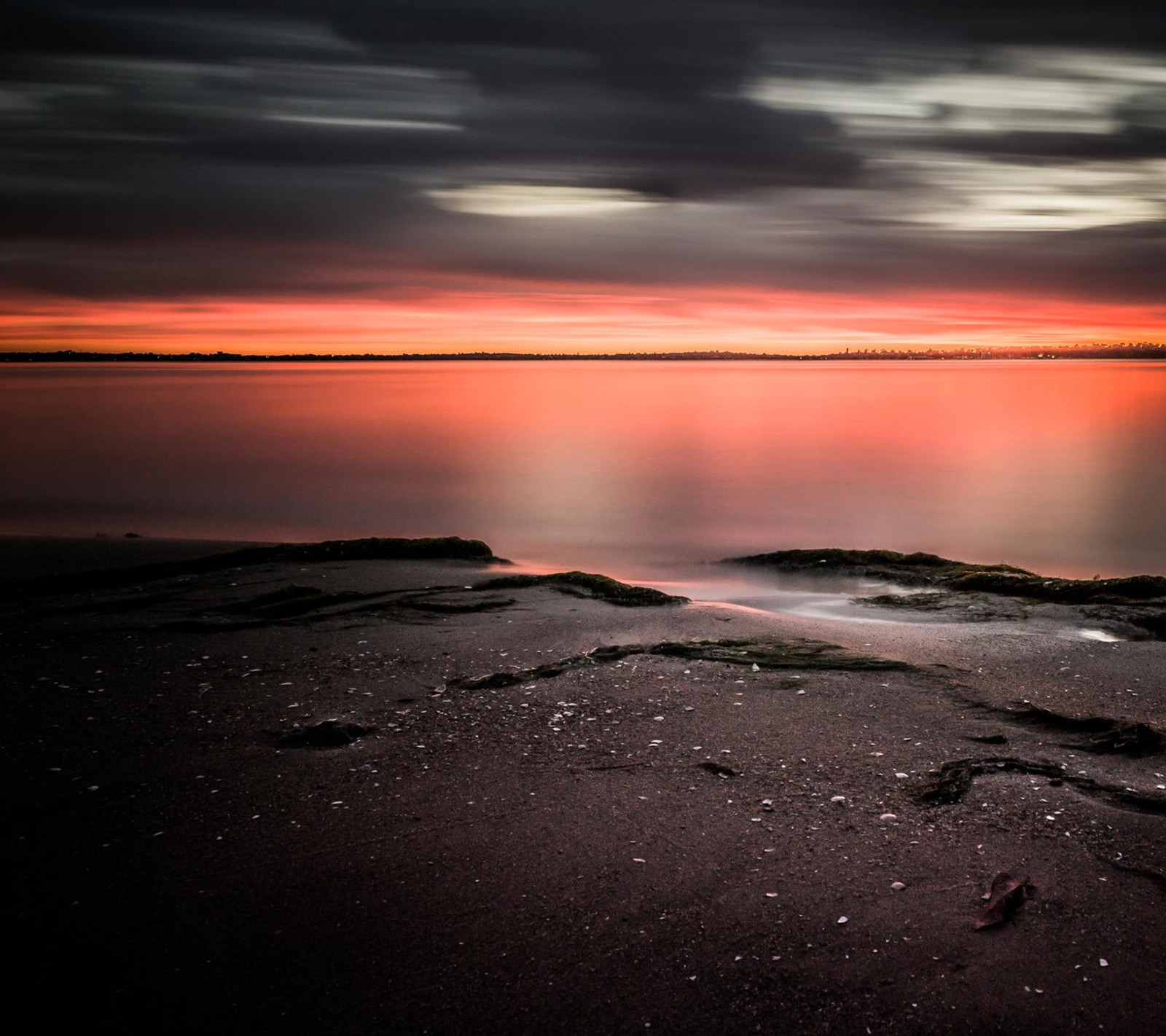 Arafed view of a sunset over a body of water (beach, sunset)