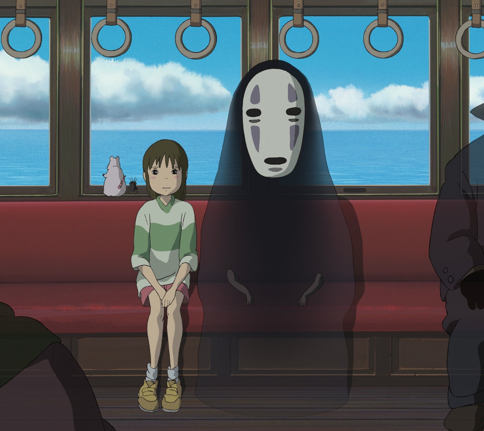 Scène d'anime d'une personne assise dans un train avec un masque facial (mei, le voyage de chihiro, studio ghibli)