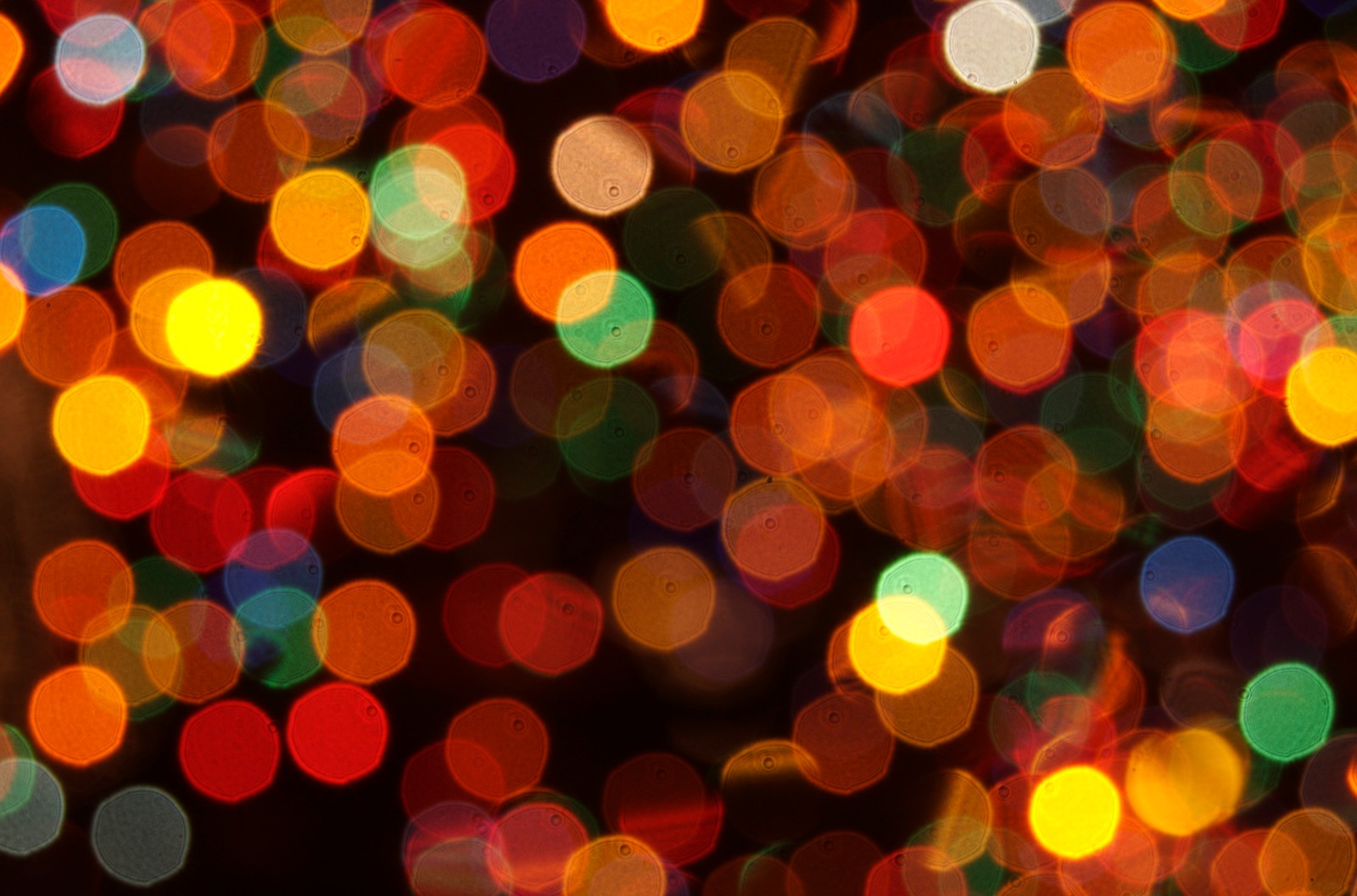 A close up of a bunch of lights that are on a tree (christmas day, light, pattern, circle, christmas eve)